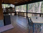 East Side of Wraparound Deck with Dining Table, TV, Gas Grill and Steps to Forest